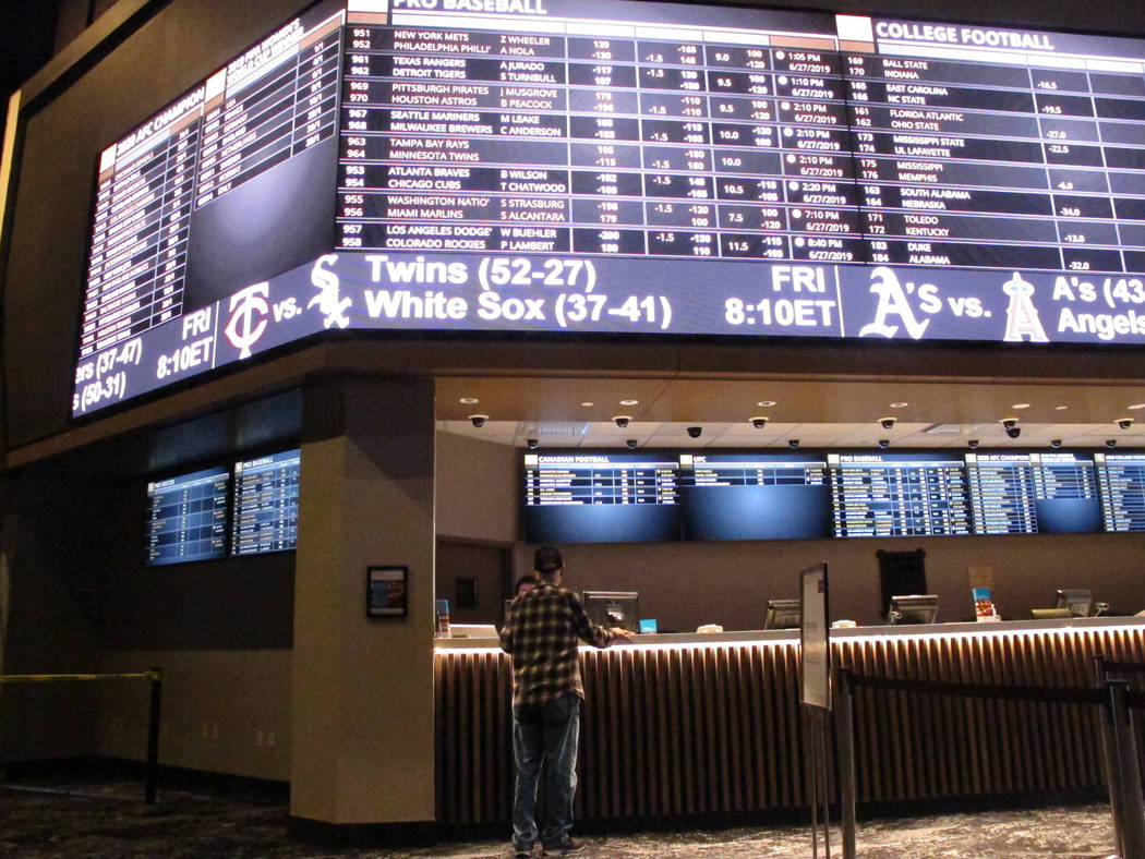 A customer ponders the odds at the new sportsbook at Bally's casino in Atlantic City, N.J., Jun ...