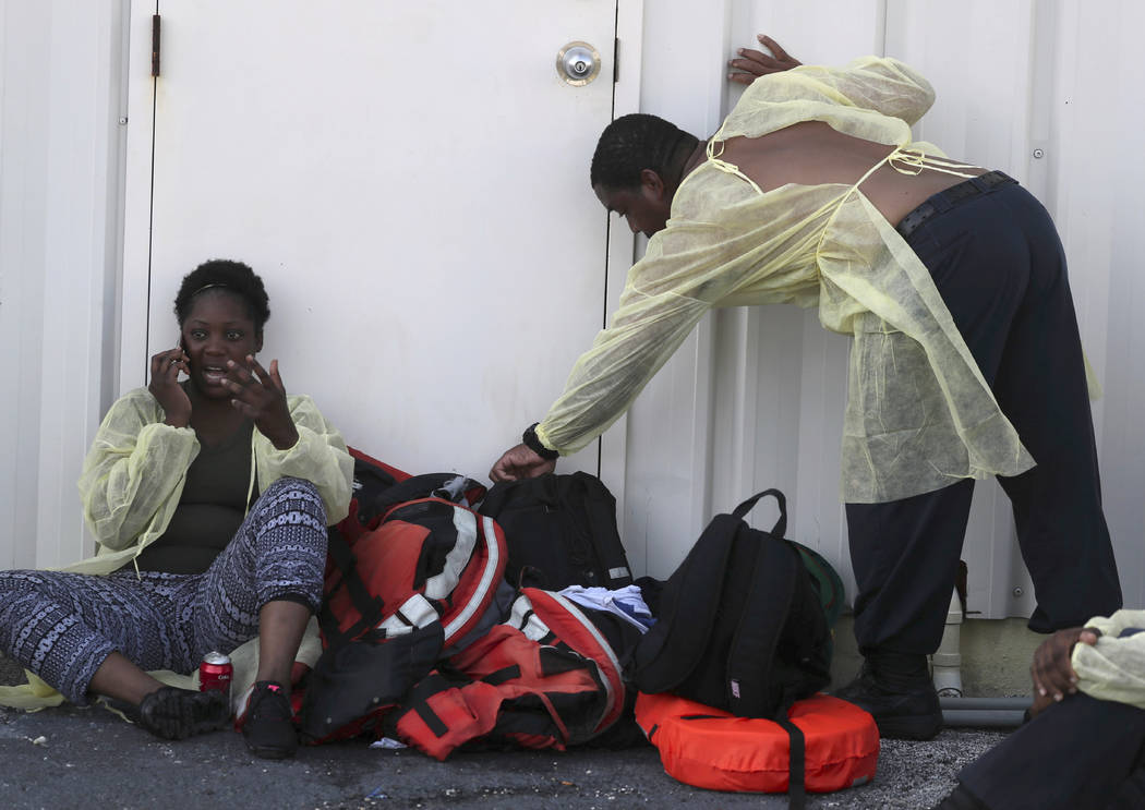 A woman, left, speaks by mobile phone after being evacuated along with others from Abaco in the ...