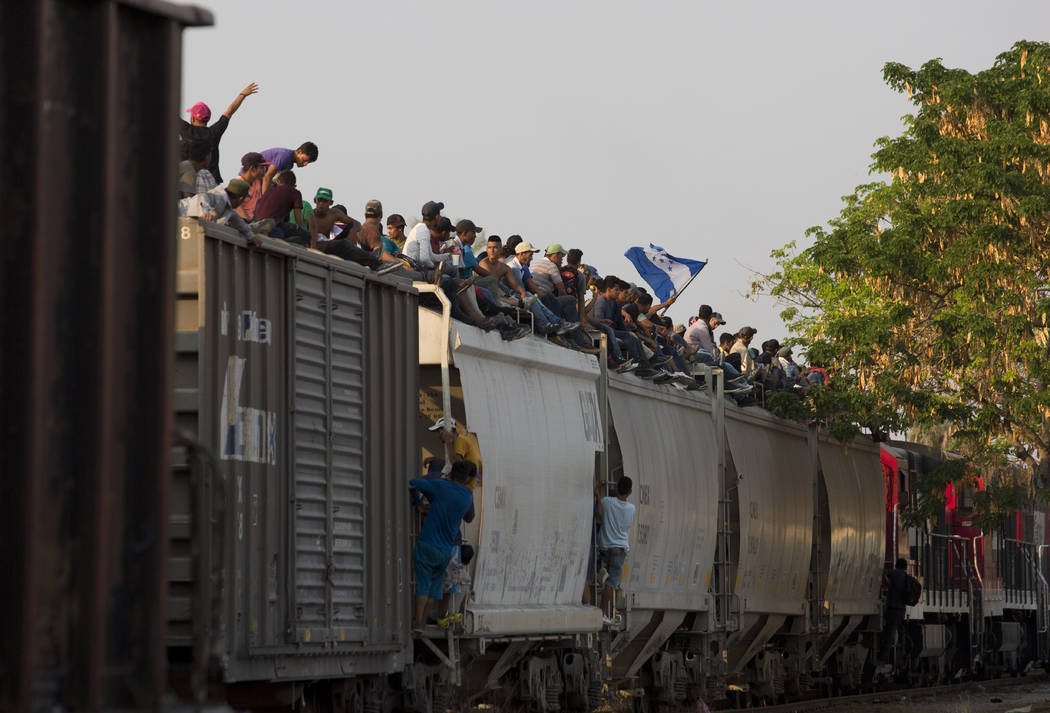 FILE - In this April 23, 2019 file photo, Central American migrants ride atop a freight train d ...