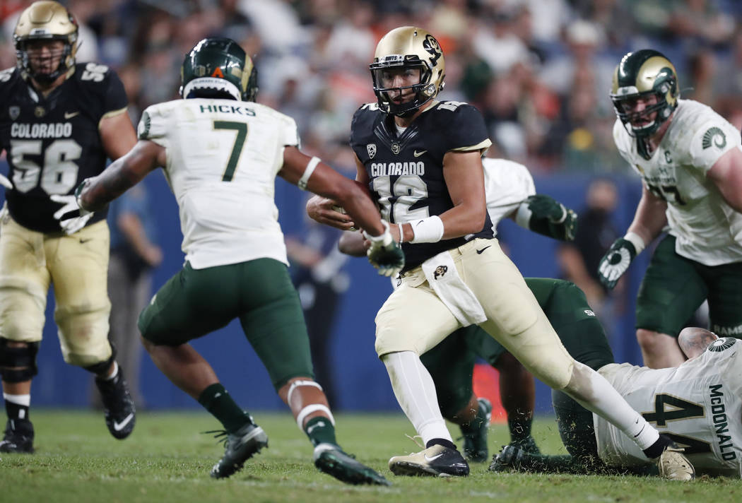 Colorado State safety Jamal Hicks, left, comes in to tackle Colorado quarterback Steven Montez, ...