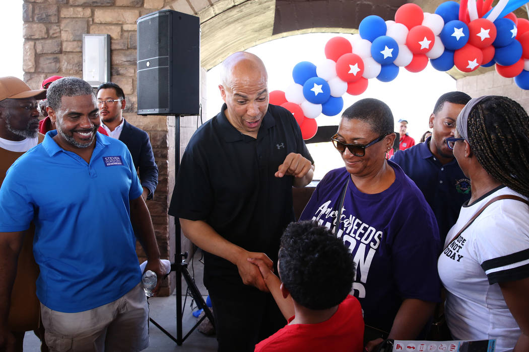 Democratic presidential candidate Sen. Cory Booker, D-N.J., second left, shakes hands with Will ...