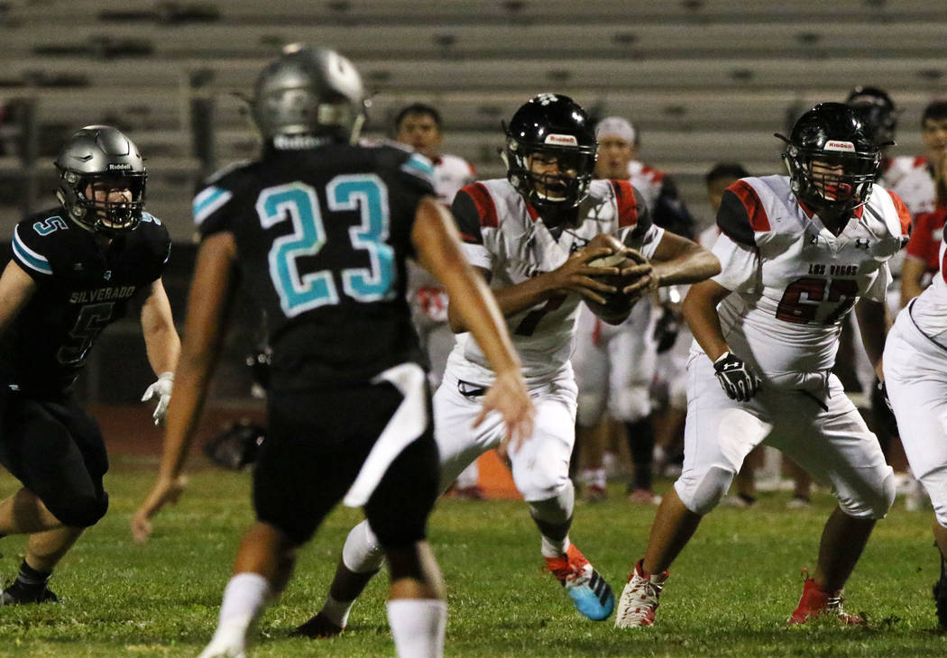 Las Vegas High's quarterback Ja'shawn Scroggins, second right, runs with the ball during the fi ...