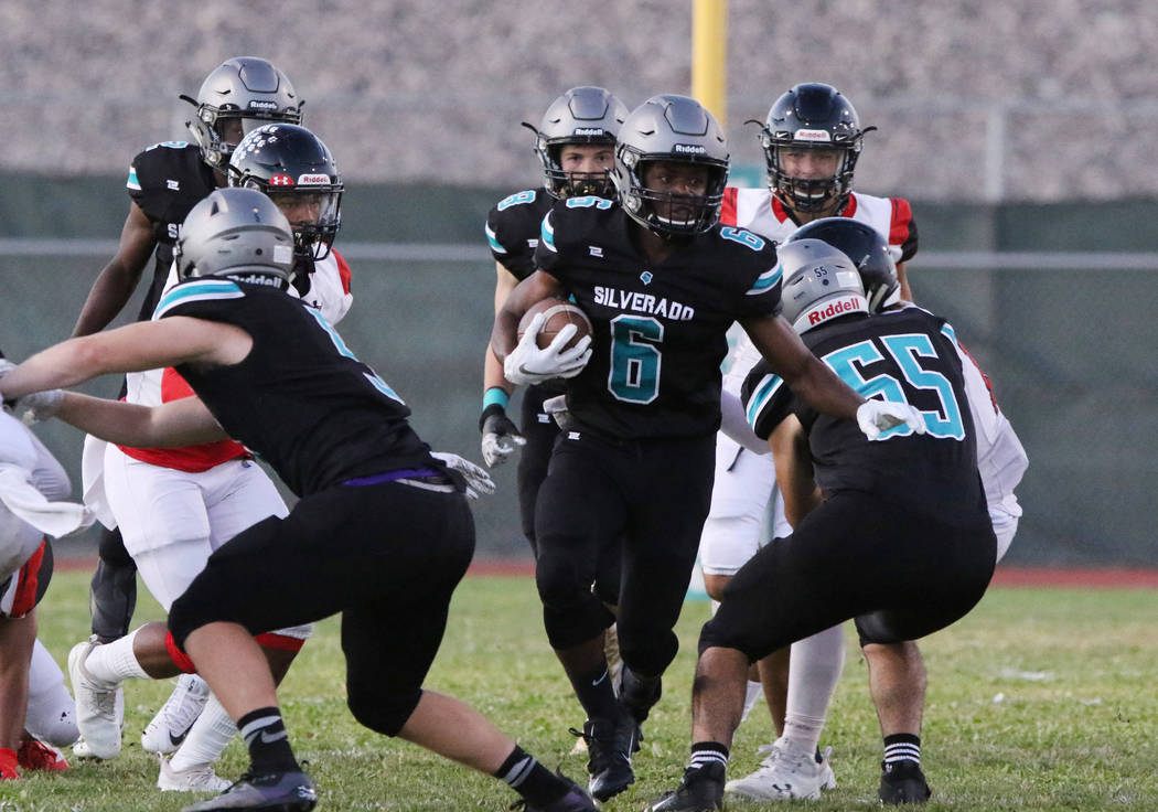 Silverado High's running back John Agonke (6) scrambles away from Las Vegas High defense during ...