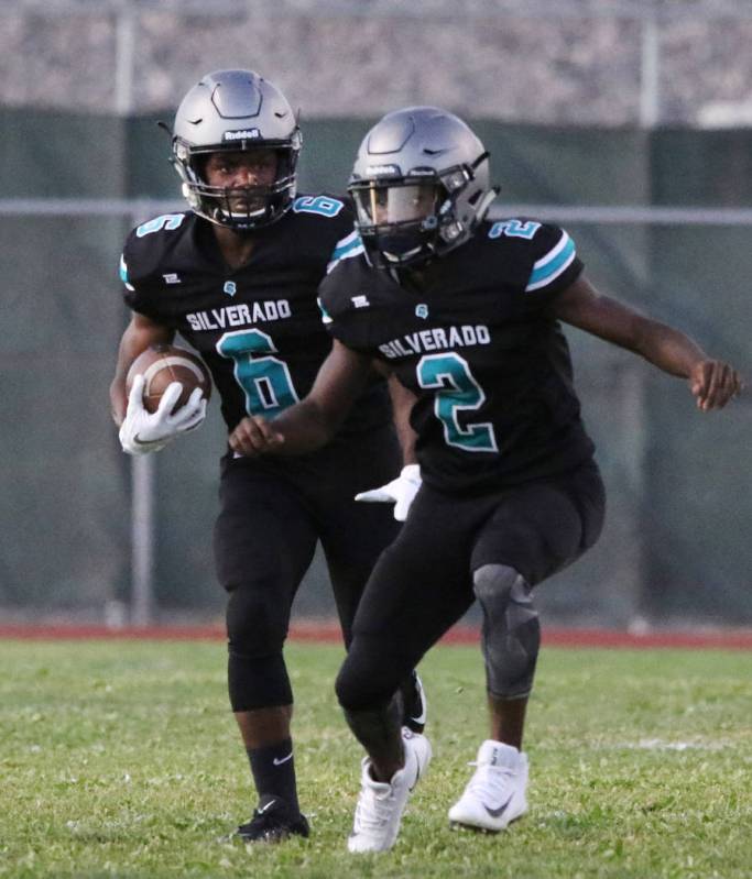 Silverado High's running back John Agonke (6) runs with the ball as his teammate Aginae Cunning ...