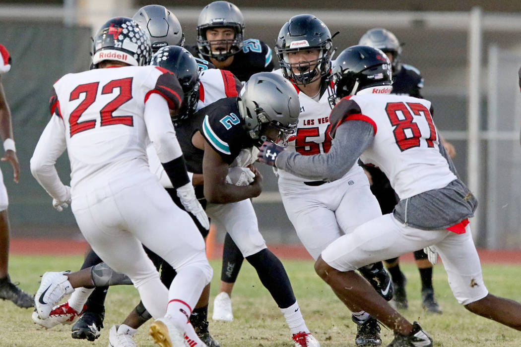 Silverado High's running back Aginae Cunningham (2) is tackled by Las Vegas High defense during ...