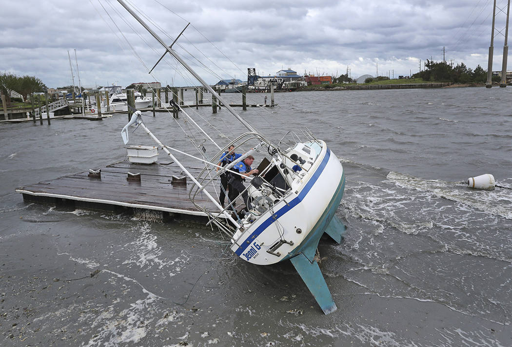 Beaufort Police Officer Curtis Resor, left, and Sgt. Micheal Stepehens check a sailboat for occ ...