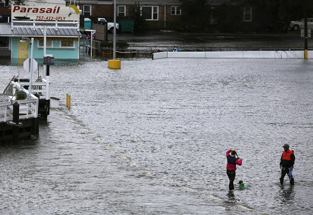 Jon Baranowski and his family play in the flooded parking lot of the Virginia Beach Fishing Cen ...