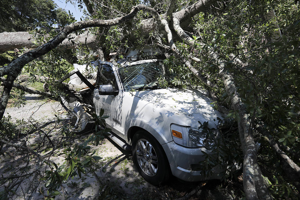 A tree brings smashes a car after Hurricane Dorian passed by James Island, S.C., Friday, Sept. ...