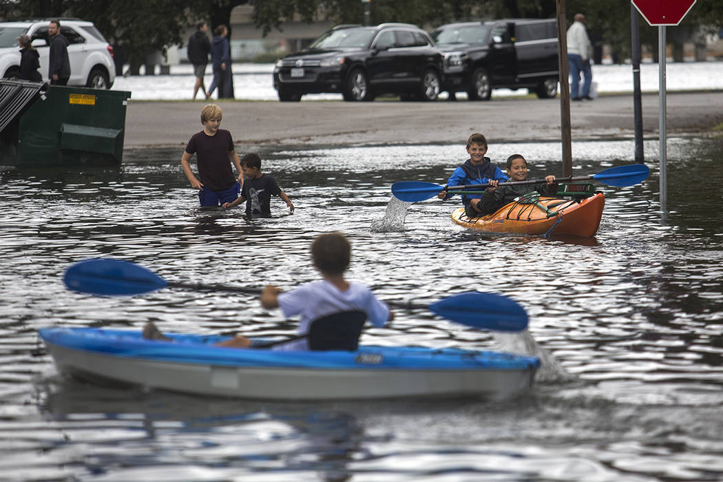 Kids kayak through the flooded streets near the corner of Mowbray Arch and Botetourt Street aft ...