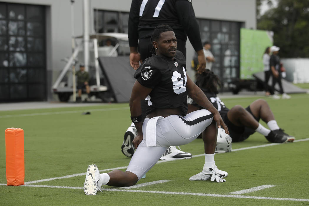 Oakland Raiders' Antonio Brown stretches during NFL football practice in Alameda, Calif., Tuesd ...