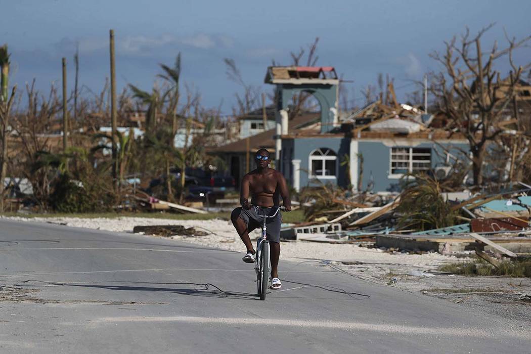 A man rides his bike amid the wreckage of Hurricane Dorian in Marsh Harbor, Abaco Island, Baham ...