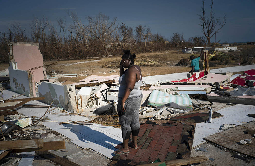 A woman is overcome as she looks at her house destroyed by Hurricane Dorian, in High Rock, Gran ...