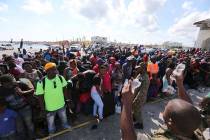 A Bahama's Army officer delivers water to the people evacuated prior boarding a ferry to Nassau ...