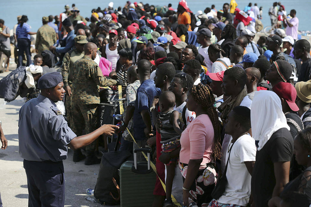 A Bahama's Army officer speaks with people evacuated prior boarding a ferry to Nassau at the Po ...