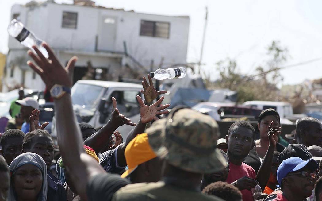 A Bahama's Army officer delivers water to people evacuated prior boarding a ferry to Nassau at ...