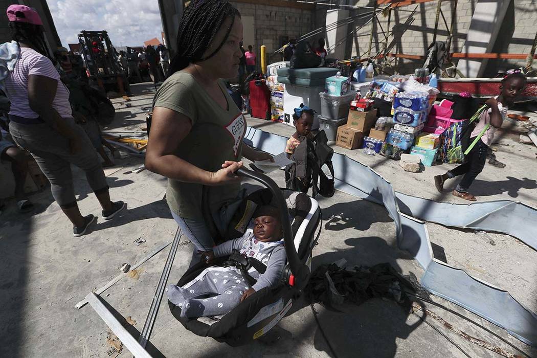 A woman carries her baby prior boarding a ferry to Nassau at the Port in Marsh Harbor, Abaco Is ...