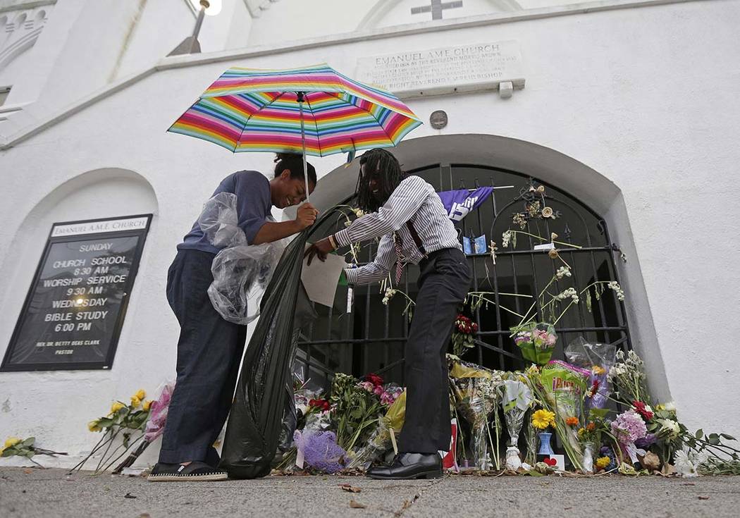 In this June 17, 2016, file photo Barrye Browne, left, and Daron Calhoun collect memorials plac ...