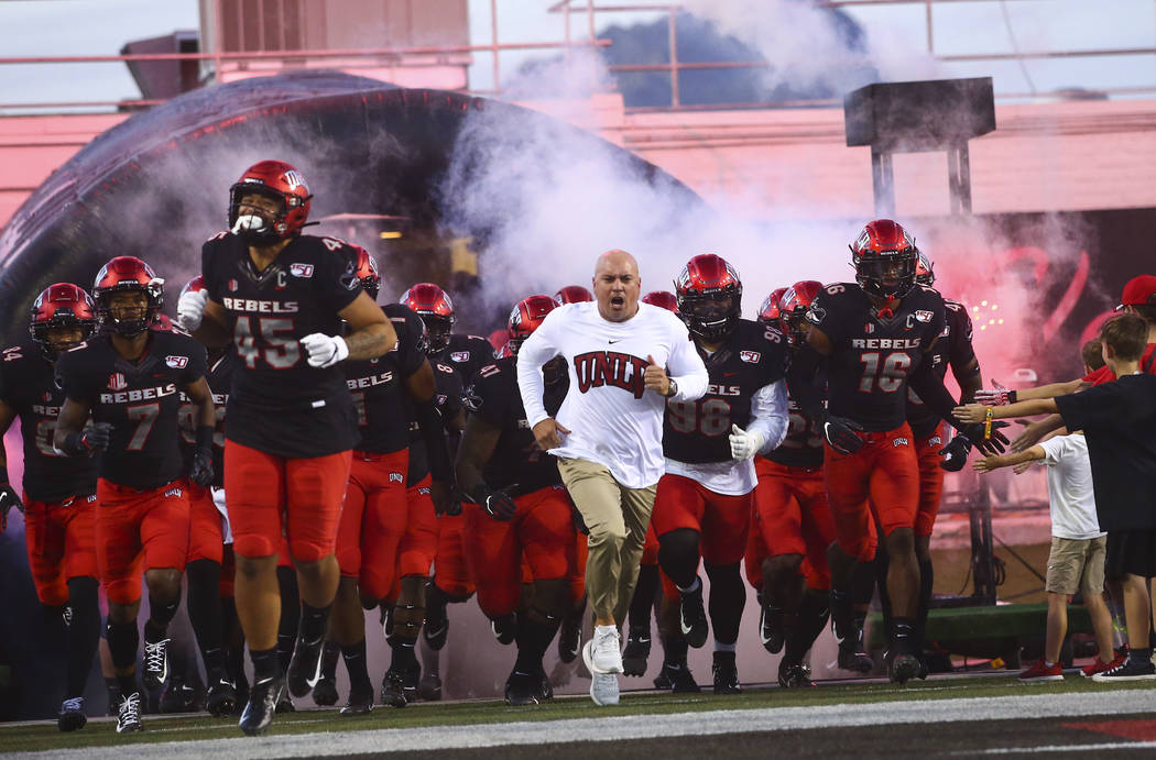 UNLV Rebels head coach Tony Sanchez leads his team onto the field before playing Arkansas Stat ...