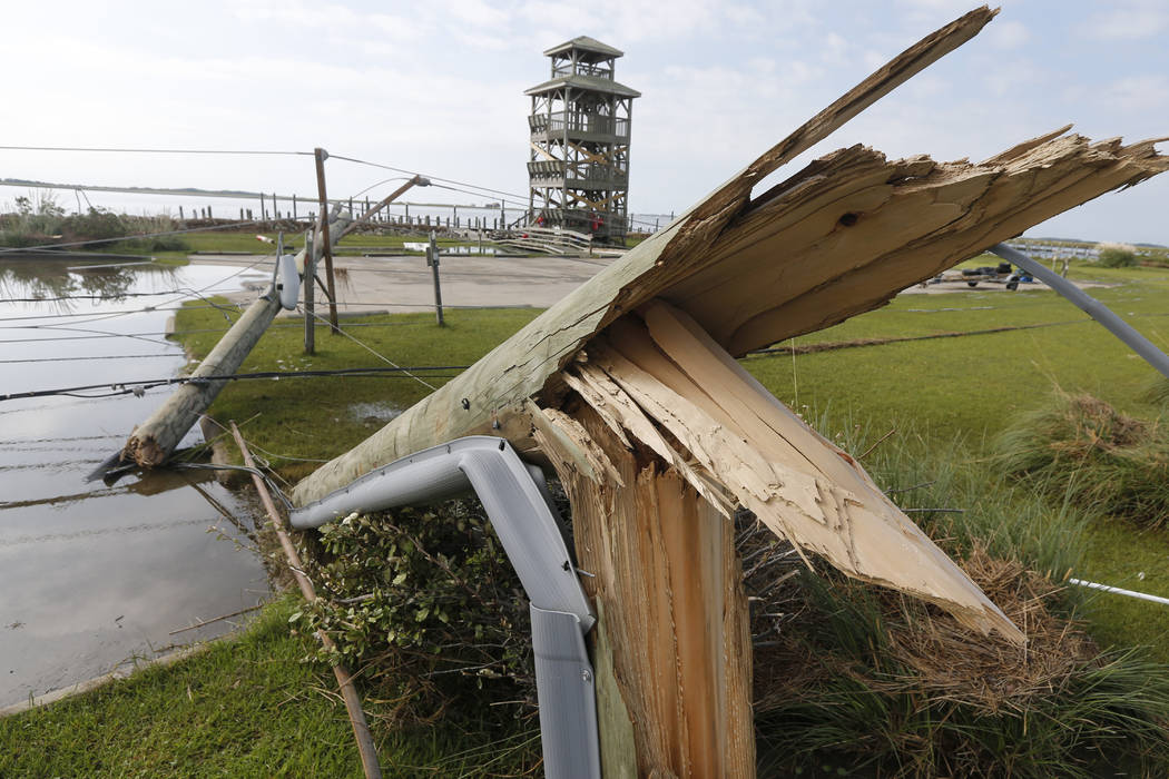 Utility poles were shipped after Hurricane Dorian moved through the area yesterday along a caus ...