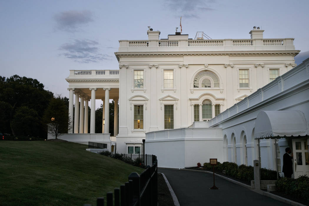 A man enters the press area of the White House at dusk, Saturday, Sept. 7, 2019, in Washington. ...