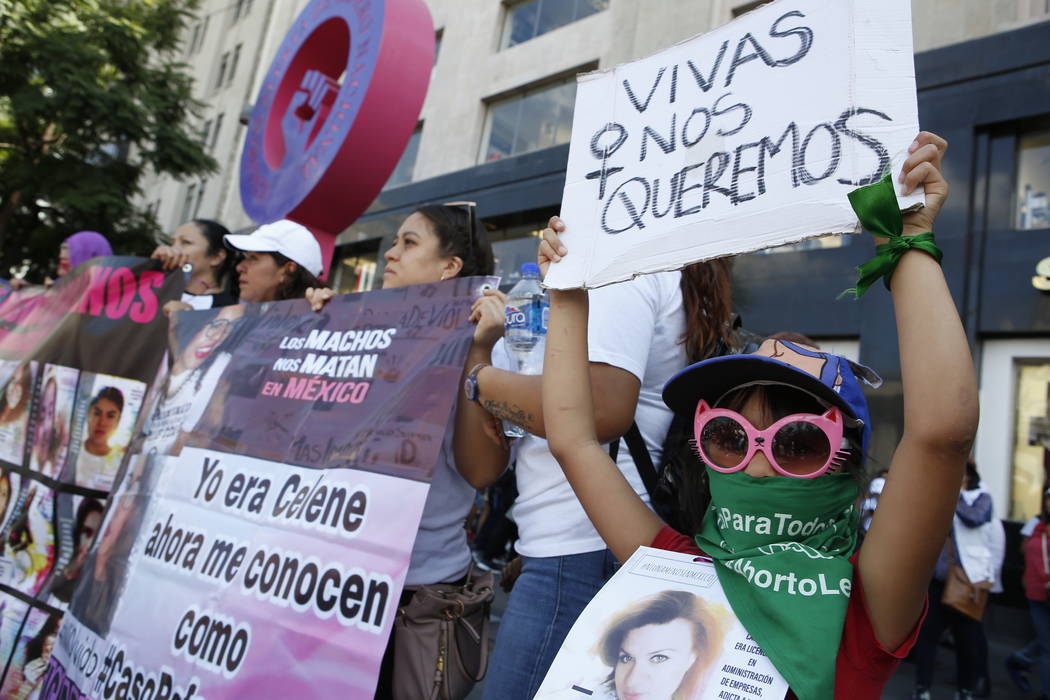 A woman holds the message "We want to be alive" during a silent march to remember mur ...