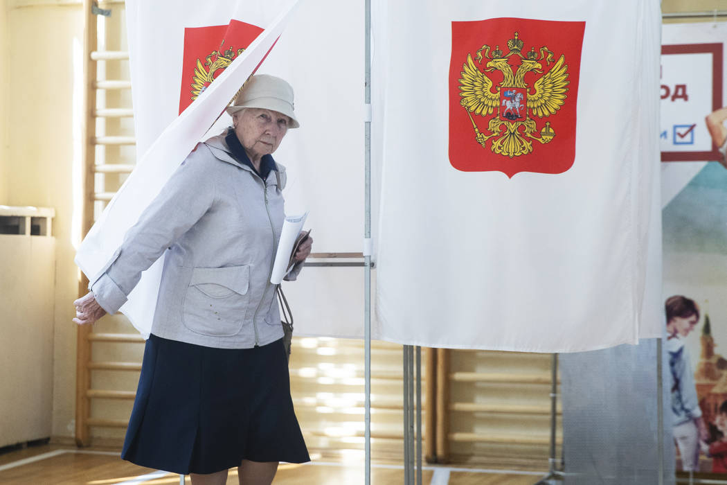 An elderly woman exits a polling booth before casting at a polling station during a city counci ...