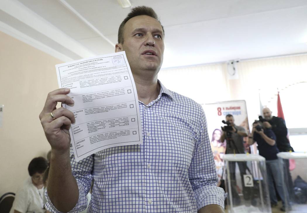 Russian opposition leader Alexei Navalny shows his ballot as he arrives to vote during a city c ...