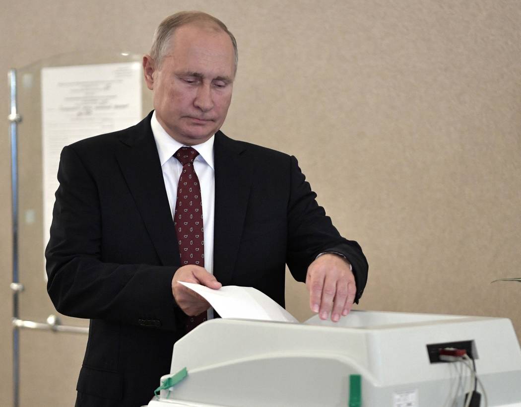 Russian President Vladimir Putin casts his ballot at a polling station during a city council el ...