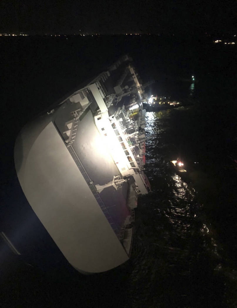 In this photo provided by the U.S. Coast Guard, the Golden Ray cargo ship lists to one side nea ...