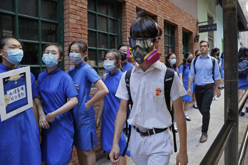 Students wearing mask hold hands to surround the St. Stephen's Girls' College in Hong Kong, Mon ...