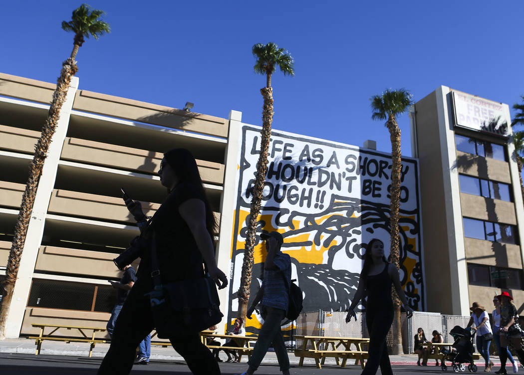 Attendees pass by a mural during the Life is Beautiful music and arts festival in downtown Las ...