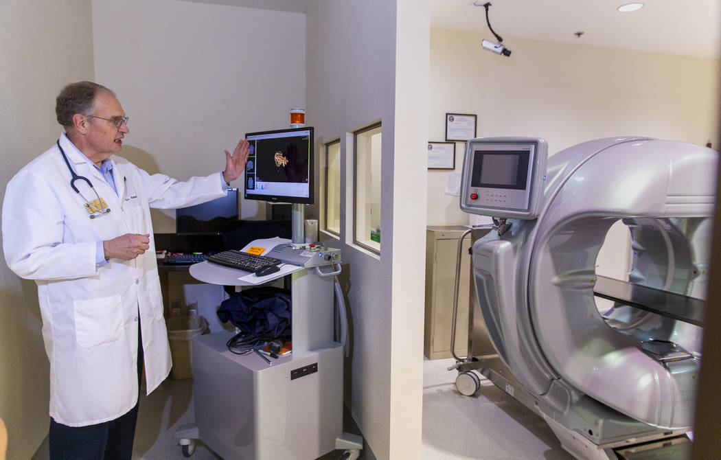 Program Director Dr. Dennis Olsen shows how they employ a computerized tomography (CT) scanner ...