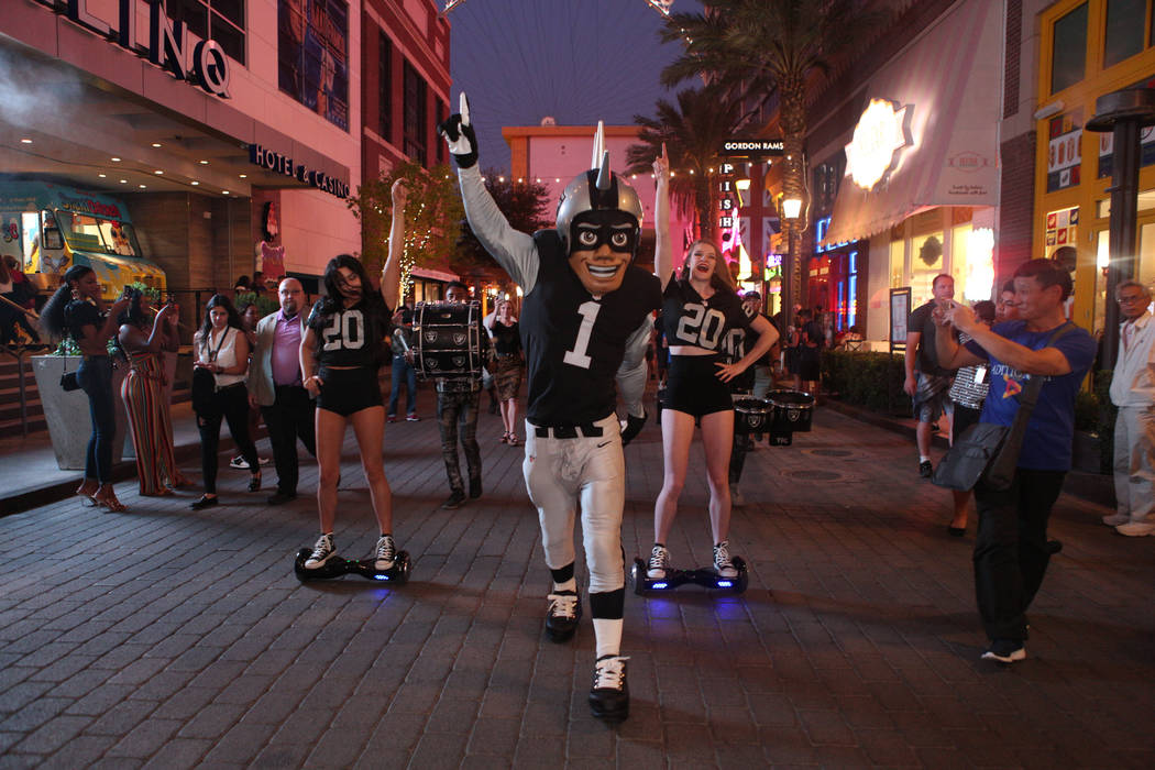 The Oakland Raiders mascot celebrates with Diana Tatevossian, left, and Kayla Kalisz, right, of ...