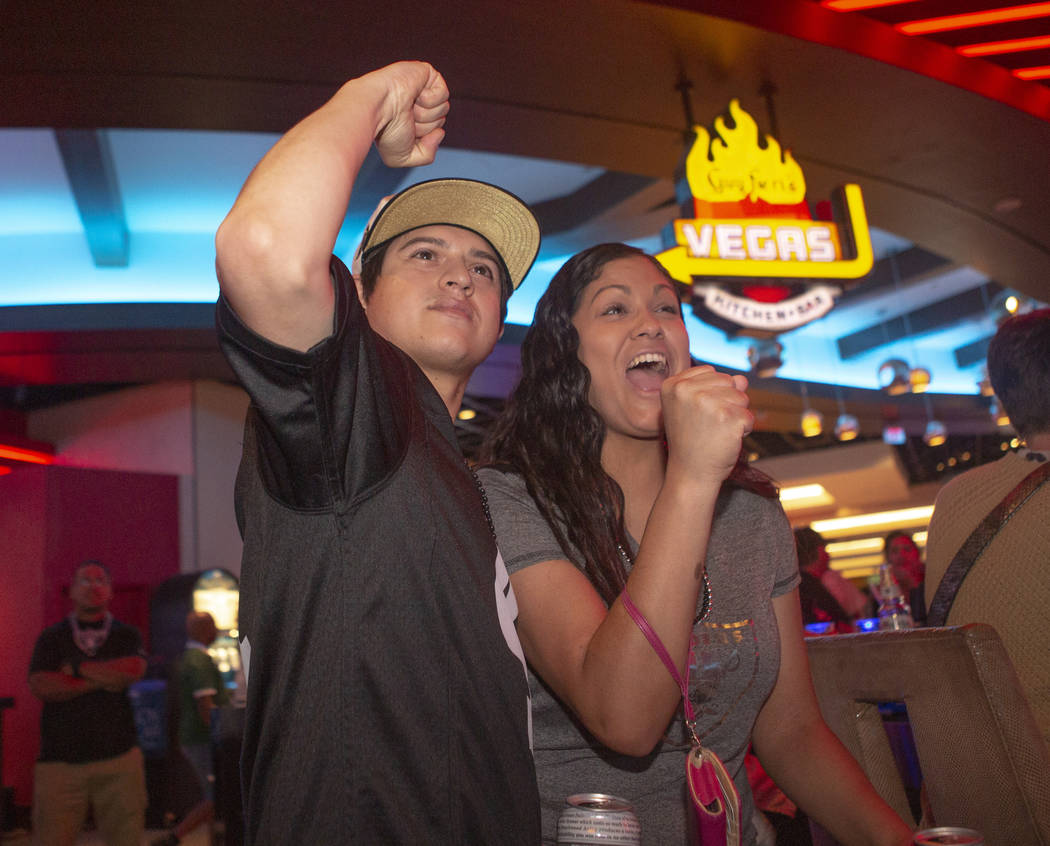 Oakland Raiders fan Jason Estrada, left, cheers with his girlfriend Demi Hart, right, during th ...