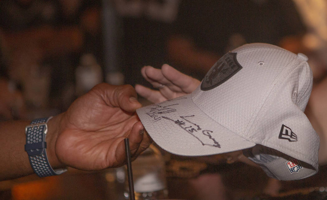 A autograph Oakland Raiders hat is signed for a fan at Linq Hotel and Casino on Monday, Sept. 9 ...