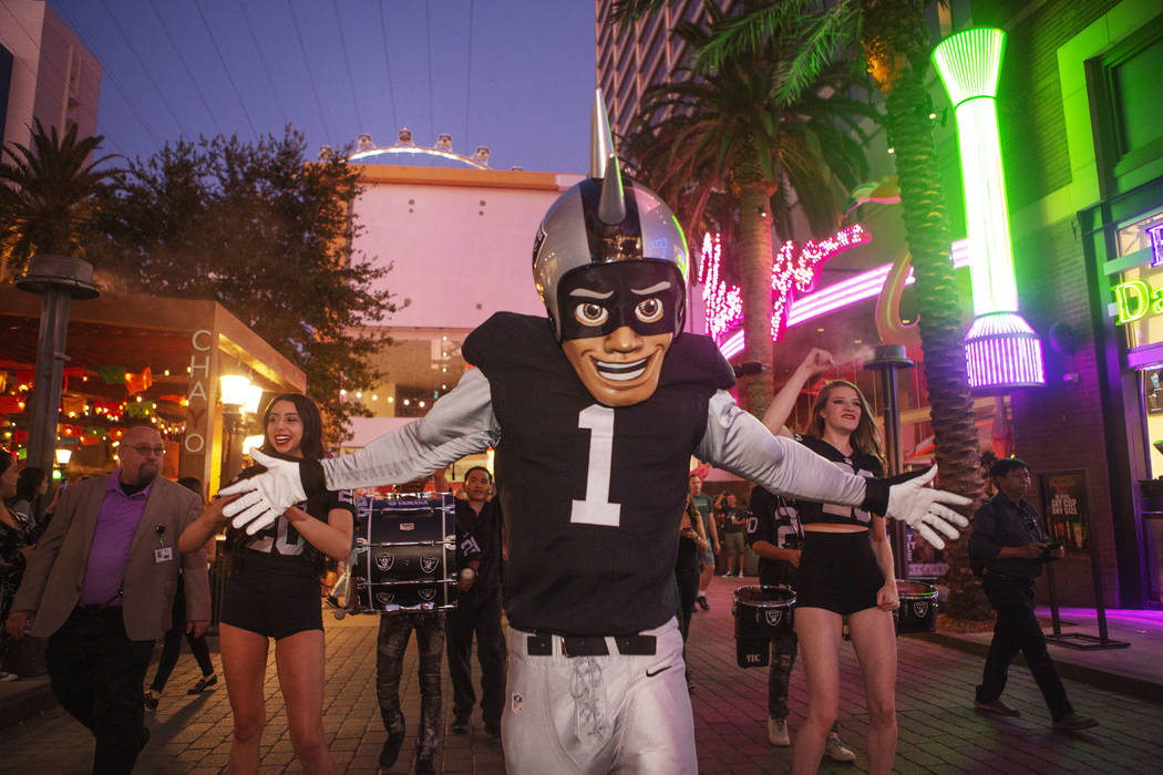 The Raiders mascot celebrates with Diana Tatevossian, left, and Kayla Kalisz, right, of Extreme ...