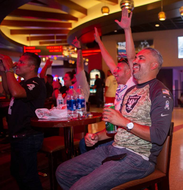 Freddy Garcia, right, from Los Angeles, celebrates after a Oakland Raiders touchdown with Rafae ...