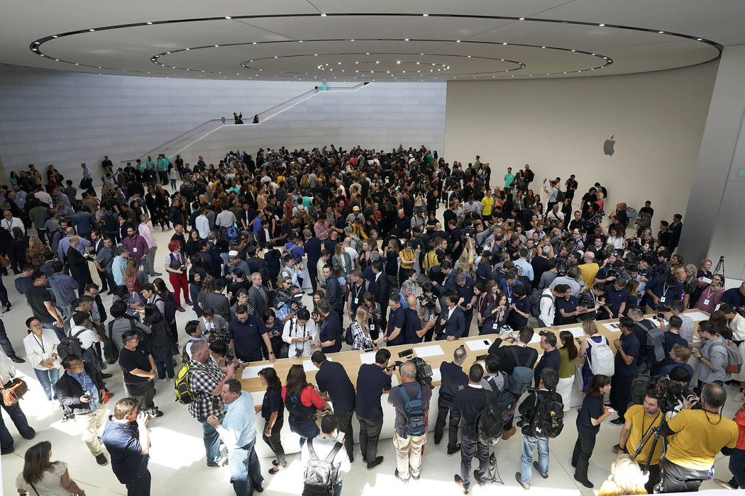 Event attendees get a look at the new products at the Steve Jobs Theater during an event to ann ...