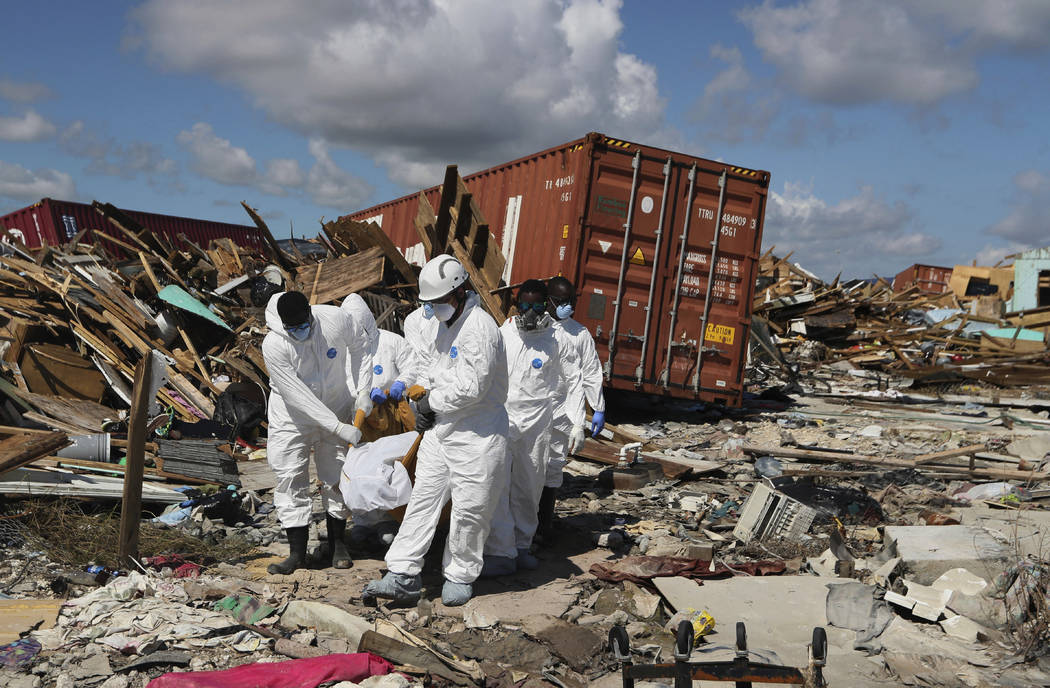 A Bahamas coroners team carries a body out of The Mudd neighborhood in the Marsh Harbor area of ...