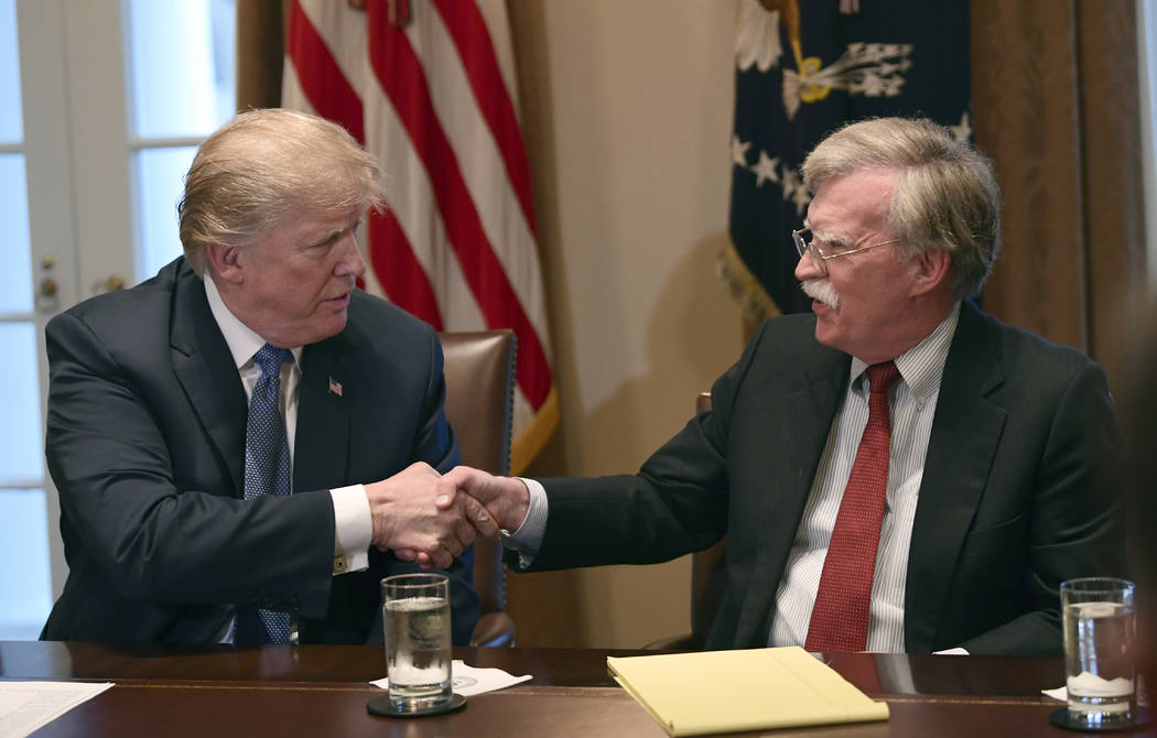 President Donald Trump, left, shakes hands with national security adviser John Bolton in the Ca ...