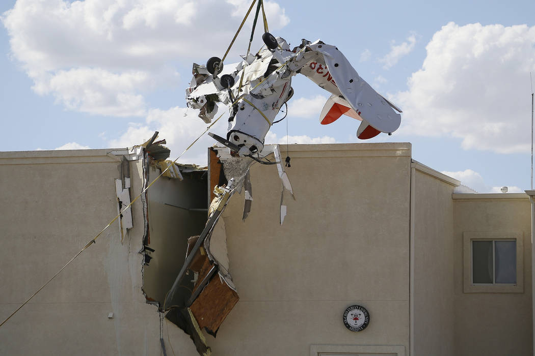 A single-engine plane is hoisted up after it crashed into the terminal building shortly after t ...