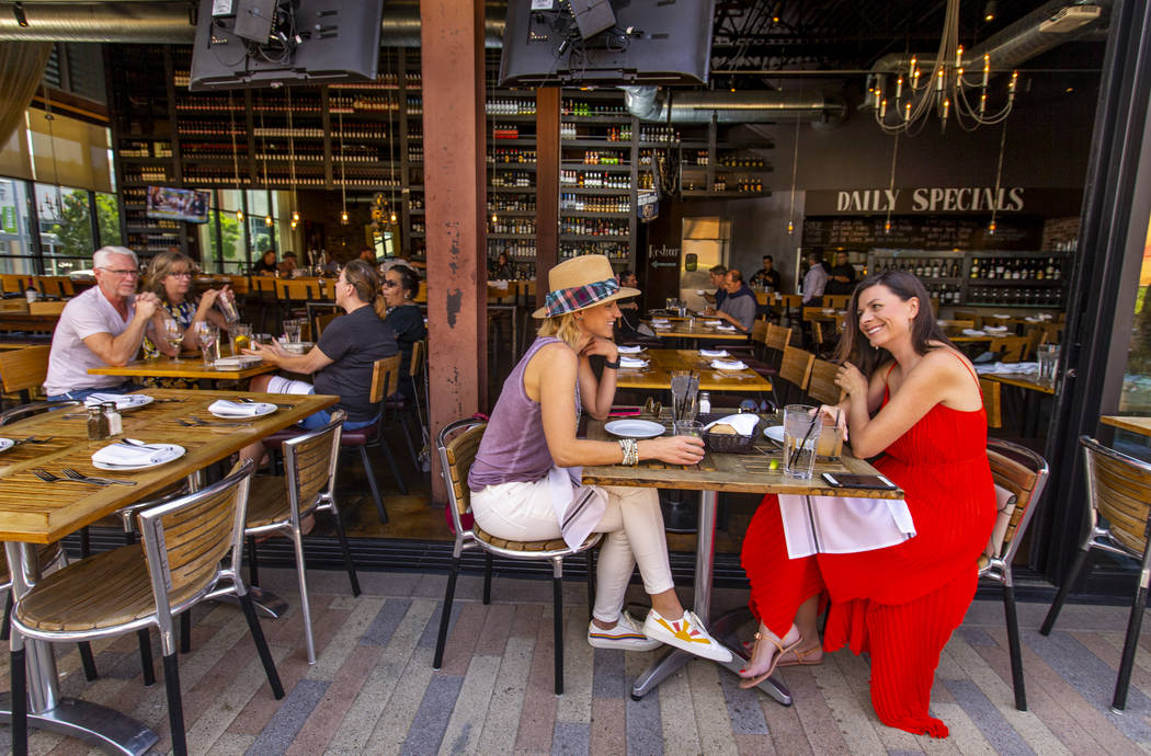 Customers Ryan Tselikis, center, and Olga McDowell, right, enjoy lunch on the deck at Grape Str ...