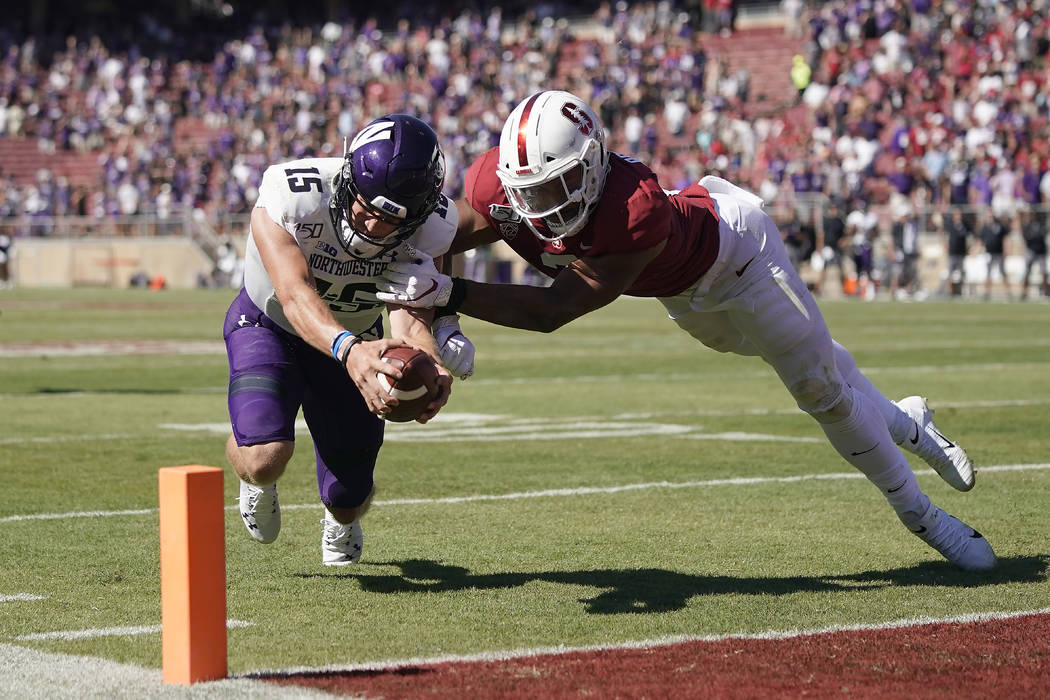 Northwestern quarterback Hunter Johnson (15) is stopped short of the end zone by Stanford lineb ...