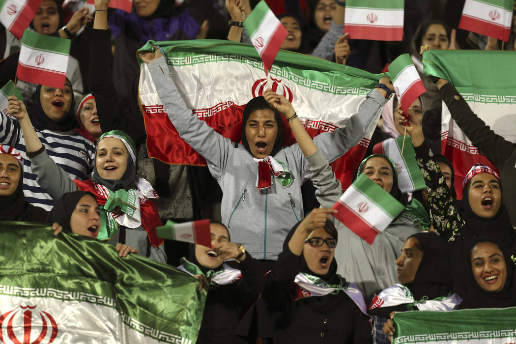 FILE - In this Oct. 16, 2018 file photo, Iranian women cheer as they wave their country's flag ...