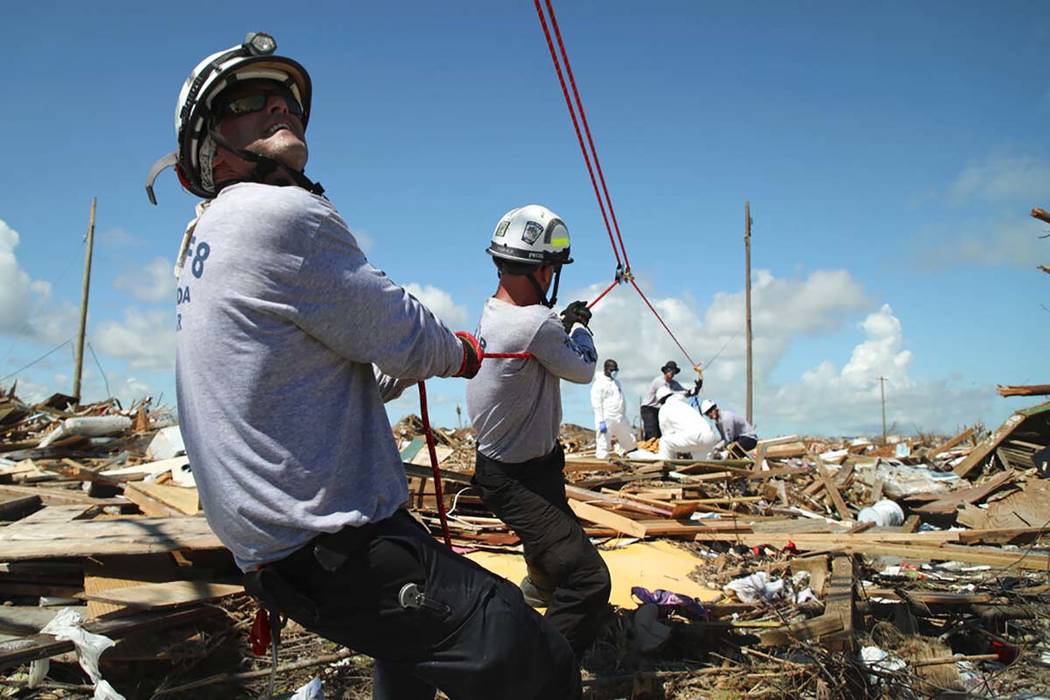 Members of the fire rescue team Task Force 8, from Gainesville, Florida, help remove a body one ...