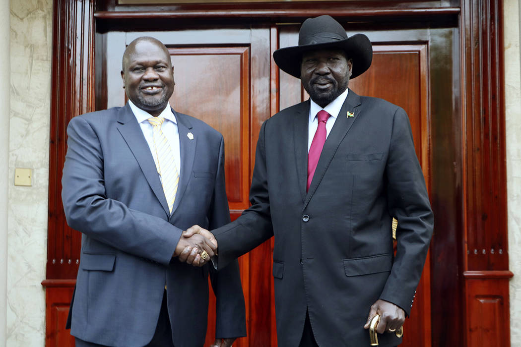 Dr. Riek Machar, left, greets South Sudan President Salva Kiir, right, on his arrival in Juba, ...