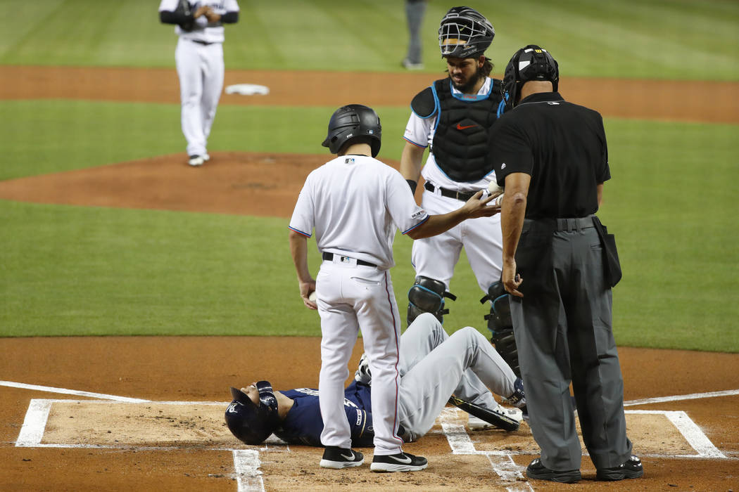 Milwaukee Brewers' Christian Yelich (22) lies on the ground after an injury during an at-bat, a ...