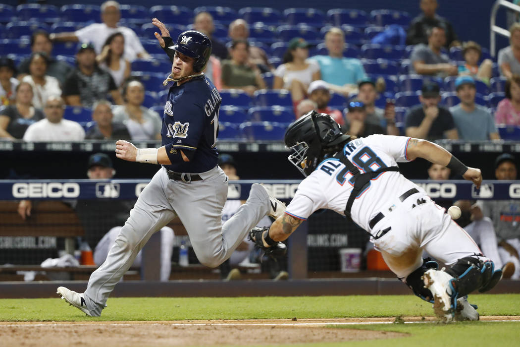 Milwaukee Brewers' Yasmani Grandal (10) heads for home plate to score on a sacrifice fly by Tyl ...