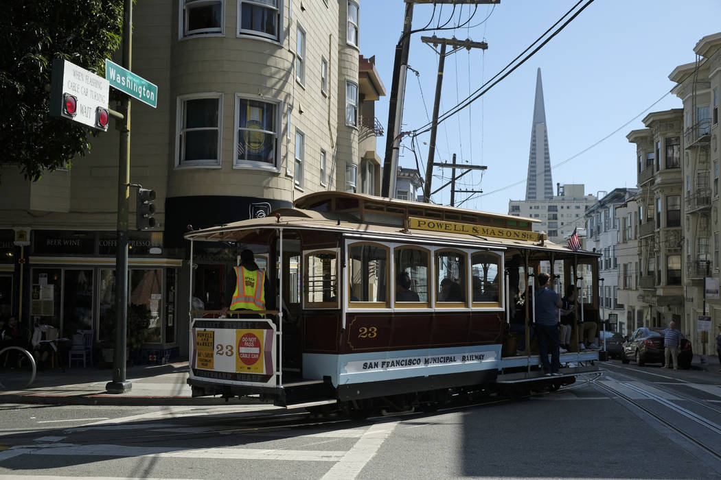 A cable car turns onto Washington Street with the Transamerica Pyramid in the background Wednes ...