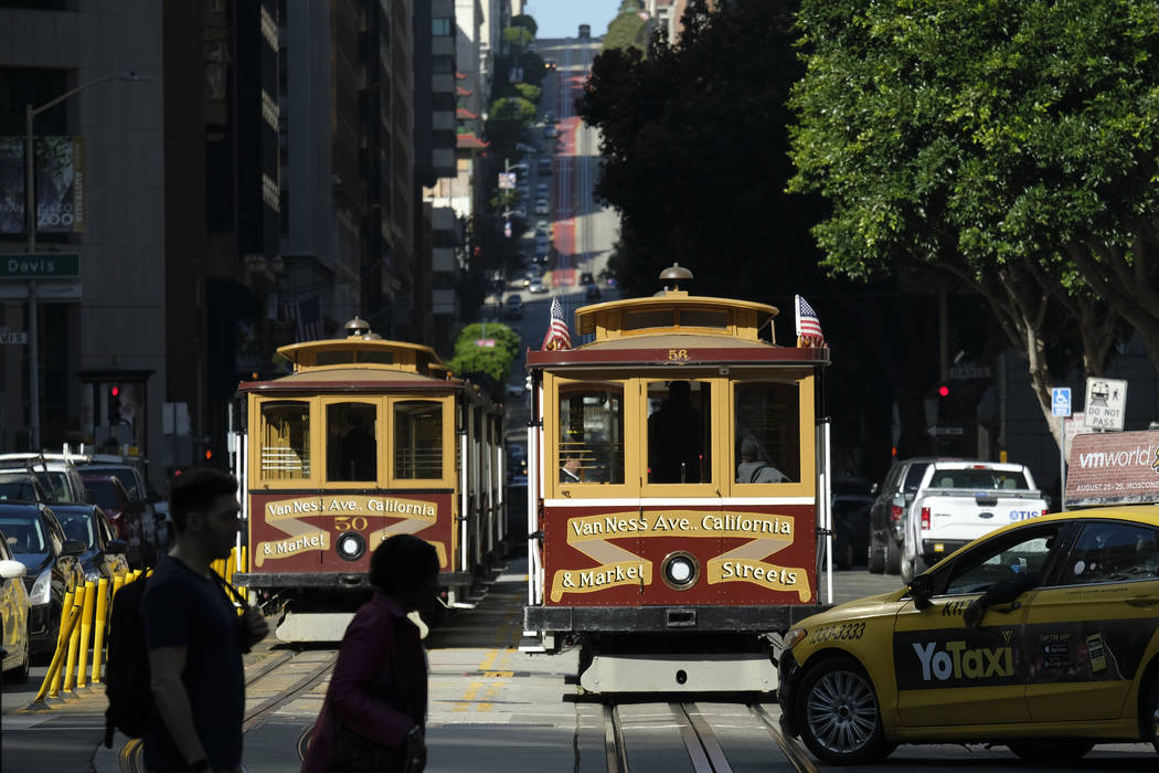 A cable car at right begins to make its way up California Street Wednesday, Sept. 11, 2019, in ...